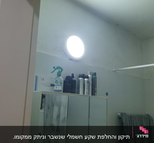 מנורה דולקת בחדר אמבטיה עם ארון מראה